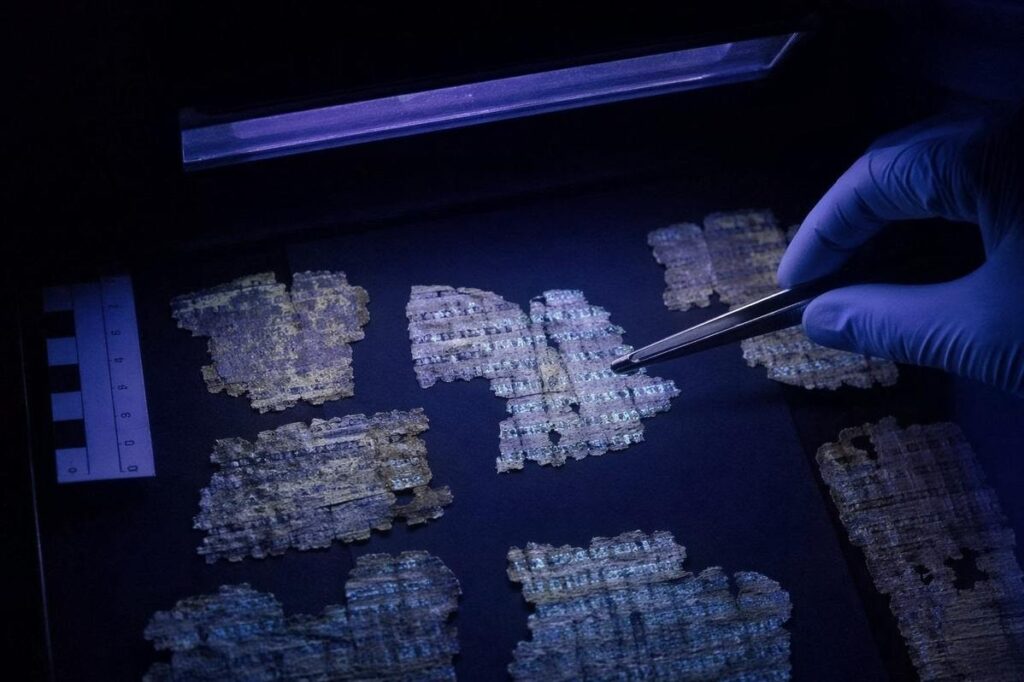 Barely legible papyrus fragments under ultraviolet conservation light