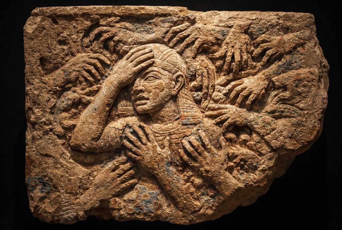 Ancient Egyptian relief showing a figure in distress among chaotic crowds representing the soul's fall