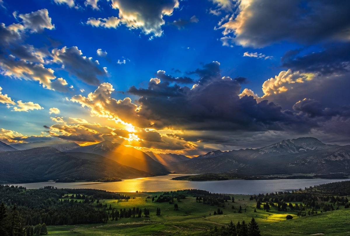 Impossibly vivid azure sky with golden light breaking through storm clouds