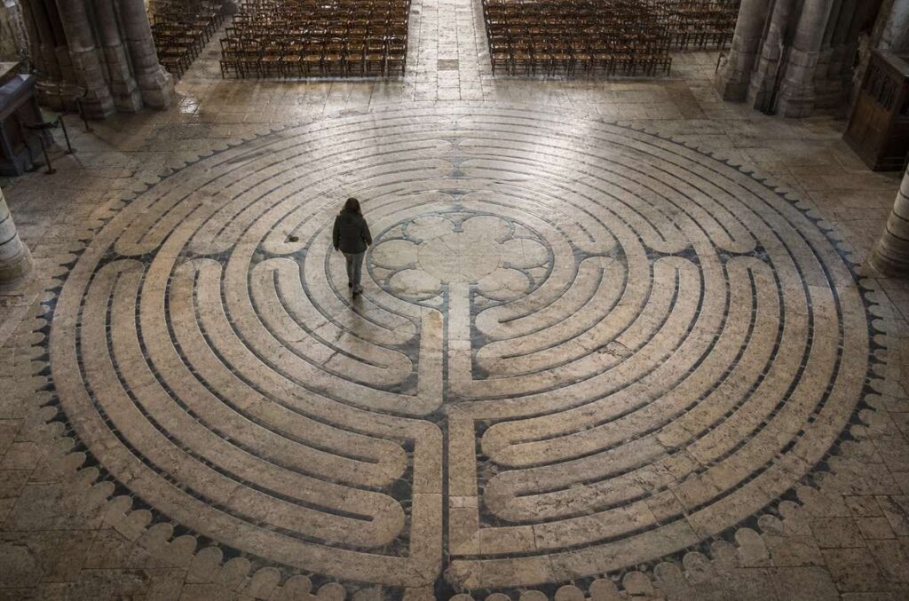 Overhead view of Chartres cathedral stone labyrinth with solitary walker on unicursal path