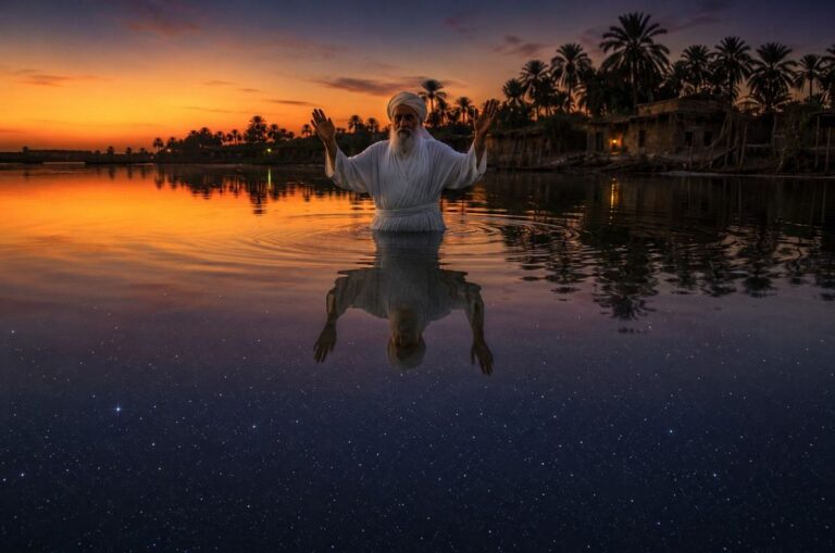 A Mandaean priest performing baptism in the Shatt al-Arab at twilight